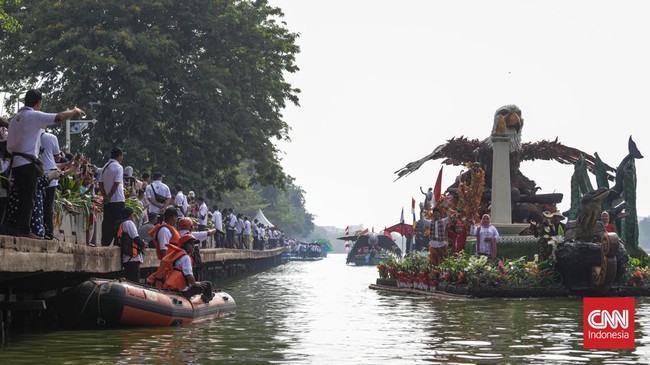 Warga menyaksikan parade perahu berbahan limbah botol plastik dan galon dalam Festival Cinta Lingkungan (Cilung) di Danau Sunter, Jakarta, Minggu (18/10). (CNN Indonesia/Febria Adha L)