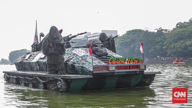 Warga menyaksikan parade perahu berbahan limbah botol plastik dan galon dalam Festival Cinta Lingkungan (Cilung) di Danau Sunter, Jakarta, Minggu (18/10). (CNN Indonesia/Febria Adha L)