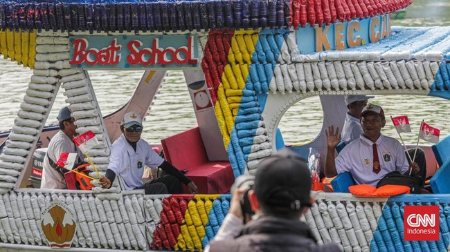 Warga menyaksikan parade perahu berbahan limbah botol plastik dan galon dalam Festival Cinta Lingkungan (Cilung) di Danau Sunter, Jakarta, Minggu (18/10). (CNN Indonesia/Febria Adha L)