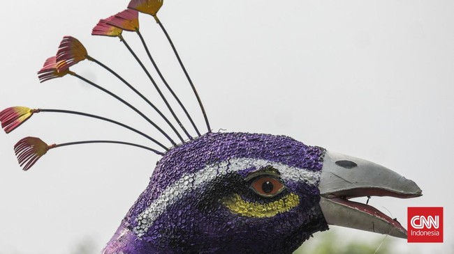 Warga menyaksikan parade perahu berbahan limbah botol plastik dan galon dalam Festival Cinta Lingkungan (Cilung) di Danau Sunter, Jakarta, Minggu (18/10). (CNN Indonesia/Febria Adha L)