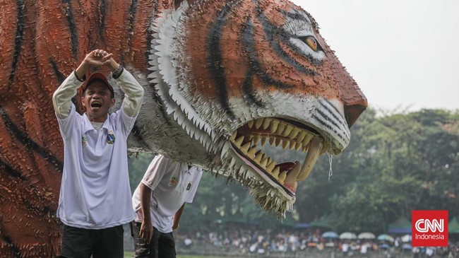 Warga menyaksikan parade perahu berbahan limbah botol plastik dan galon dalam Festival Cinta Lingkungan (Cilung) di Danau Sunter, Jakarta, Minggu (18/10). (CNN Indonesia/Febria Adha L)
