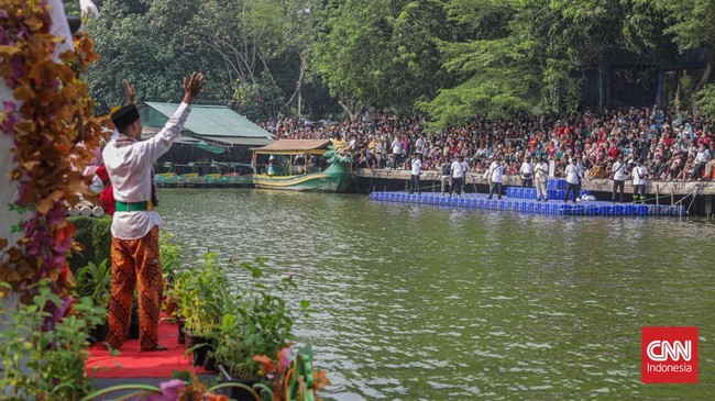 Warga menyaksikan parade perahu berbahan limbah botol plastik dan galon dalam Festival Cinta Lingkungan (Cilung) di Danau Sunter, Jakarta, Minggu (18/10). (CNN Indonesia/Febria Adha L)