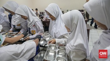 Sejumlah siswa mengambil menu Makanan Bergizi Gratis (MBG) dengan konsep prasmanan di SMP Kemala Bhayangkari 3, Ragunan, Jakarta, Kamis (15/10/2026). (CNN Indonesia/Febria Adha L)