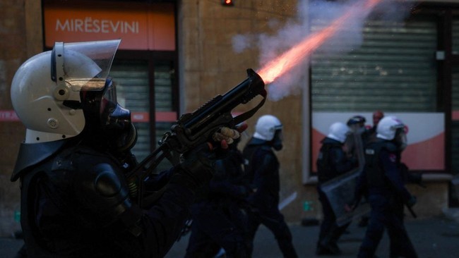 A police officer in riot gear shoots tear gas during an anti-government protest by students in Tirana, Albania, October 18, 2026. REUTERS/Florion Goga