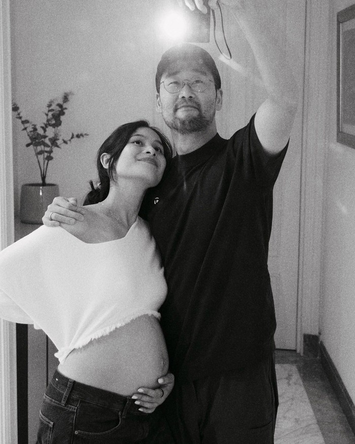 Dalam potret ketiga, ia berfoto bersama sang suami, Jesse Choi, sambil memperlihatkan baby bump tersebut. Maudy mengatakan bahwa ia dan suaminya tidak sabar bertemu dengan anak pertamanya itu beberapa bulan lagi.&nbsp;(Foto: Instagram.com/maudyayunda)
