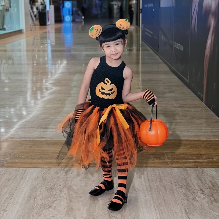 <p>Melalui unggahan di Instagram, Ricis mem-posting foto sang putri saat mengenakan kostum Halloween bernuansa warna hitam dan <em>orange</em>. Untuk menyempurnakan gayanya, bocah berusia empat tahun ini memakai banyak aksesoris bermotif buah labu, yang kerap dikaitkan dengan Halloween. (Foto: Instagram @riaricis1795)</p>