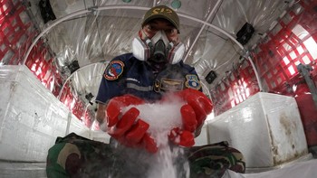 Prajurit TNI AU menunjukkan dry ice atau es kering sebagai bahan semai untuk Operasi Modifikasi Cuaca (OMC) di dalam pesawat Cassa C-212 milik Skadron IV Wing Udara 1.2 Grup 1 Angkut Lanud Abdulrachman Saleh di Base Ops Lanud Sri Mulyono Herlambang (