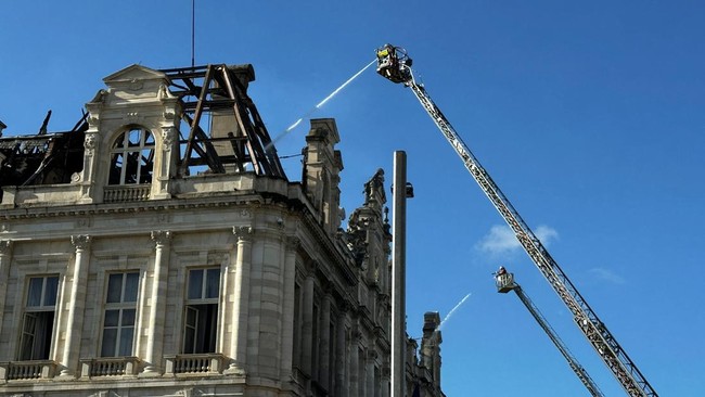 Water is sprayed over the burnt and destroyed Limoges town hall, which was set ablaze and largely destroyed in an arson attack amid demonstrations against the cost of living and rising fuel prices, in Limoges, France, October 18, 2026. Picture taken