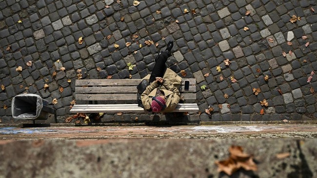 A woman rests on the Main river embankment in Frankfurt am Main, western Germany, on October 19, 2026, as air temperatures reached 16 degrees Celsius. (Photo by Kirill KUDRYAVTSEV / AFP)