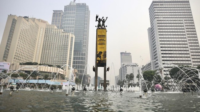 Greenpeace Indonesia activists unfurled two giant banners from the top of the Welcome Statue at the Hotel Indonesia Roundabout, Central Jakarta. One banner facing north read: Take Action on the Climate Crisis, Bring Down the Cost of Living faced nort