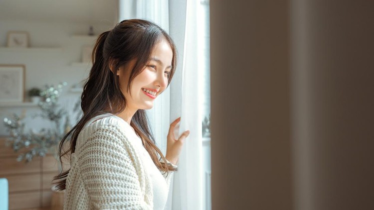 Happy young asian woman opening curtain at home&comma; Smiling attractive lady looking outside apartment enjoying dreaming and contemplating feeling hope concept