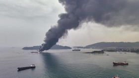 An aerial view shows smoke billowing from the KMP Batumandi ferry after it caught fire in waters off Merak in Cilegon, Banten province on October 20, 2026. (Photo by GANIS BUNGSU / AFP)