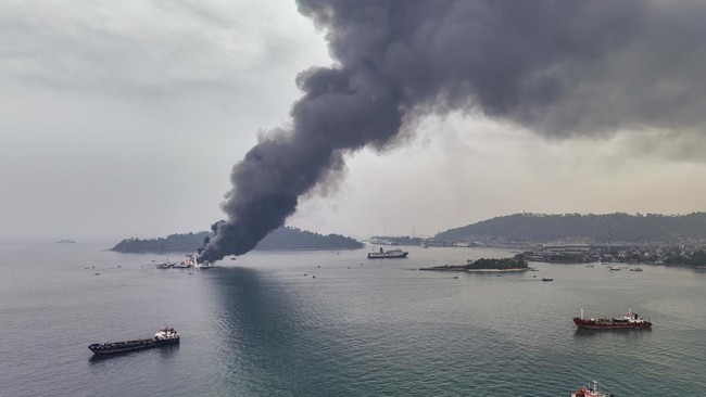 An aerial view shows smoke billowing from the KMP Batumandi ferry after it caught fire in waters off Merak in Cilegon, Banten province on October 20, 2026. (Photo by GANIS BUNGSU / AFP)