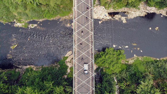 Foto udara kondisi Sungai CIleungsi berwarna hitam diduga tercemar limbah di Wanaherang, Gunung Putri, Kabupaten Bogor, Jawa Barat, Selasa (20/10/2026). Dinas Lingkungan Hidup (DLH) menyebut bahwa penyebab kembali menghitamnya aliran Sungai Cileungsi