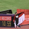 Pelari para Indonesia Karisma Evi Tiarani berfoto bersama papan catatan waktu rekor dunianya usai finis pada final 100 meter T63 Asian Para Games 2026 di Stadion Paloma Mizuho, Nagoya, Aichi, Jepang, Rabu (21/10/2026). Tiarani berhasil meraih medali