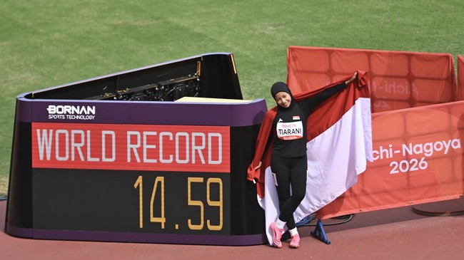 Pelari para Indonesia Karisma Evi Tiarani berfoto bersama papan catatan waktu rekor dunianya usai finis pada final 100 meter T63 Asian Para Games 2026 di Stadion Paloma Mizuho, Nagoya, Aichi, Jepang, Rabu (21/10/2026). Tiarani berhasil meraih medali