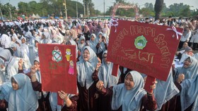Santri membawa poster saat mengikuti Apel Hari Santri Nasional 2026 di Taman Elektrik, Kota Tangerang, Banten, Kamis (22/10/2026). Ribuan santri dari berbagai pesantren dan perguruan Islam mengikuti apel tersebut untuk memperingati Hari Santri Nasion