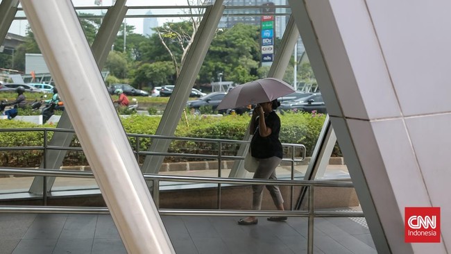 Warga Jakarta beraktivitas di bawah terik matahari yang menyengat pada Kamis (22/10/2026). Panas siang hari belakangan ini membuat kegiatan di luar ruangan terasa menyiksa, bahkan ketika termometer hanya menunjukkan kisaran 33 hingga 35 derajat Celsi