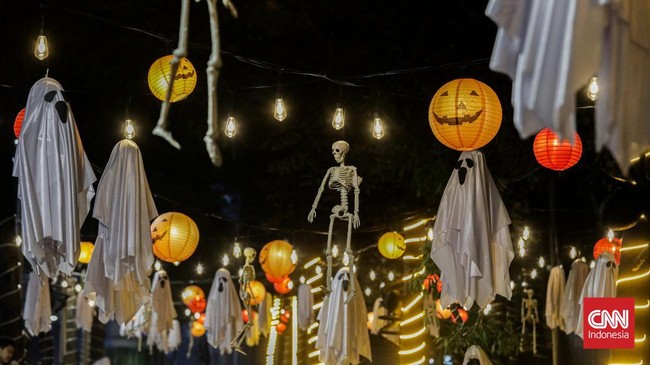 Sejumlah pejalan kaki melintasi instalasi bertema Halloween di sepanjang trotoar kawasan Sudirman, Jakarta, Rabu (21/10/2026). (CNN Indonesia/Febria Adha L)