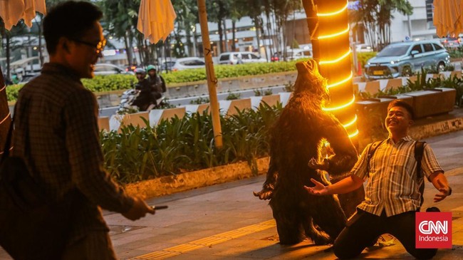 Sejumlah pejalan kaki melintasi instalasi bertema Halloween di sepanjang trotoar kawasan Sudirman, Jakarta, Rabu (21/10/2026). (CNN Indonesia/Febria Adha L)