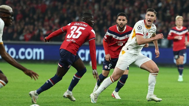 Galatasaray's Nigerian forward #45 Victor Osimhen (L) runs with the ball past Lille's French forward #35 Soriba Diaoune and Galatasaray's Hungarian forward #07 Roland Sallai (R) during the UEFA Champions League first round day 3 football match betwee