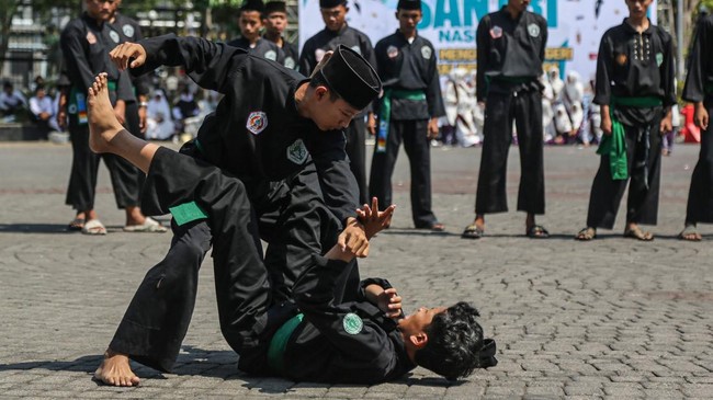 Dua santri menampilkan atraksi jurus pencak silat seusai mengikuti apel peringatan Hari Santri Nasional di halaman Balai Kota Semarang, Jawa Tengah, Kamis (22/10/2026). Ratusan santri dan pelajar dari berbagai sekolah serta pondok pesantren mengikuti