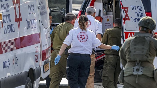 An injured person is transported into an ambulance at the scene of an earlier fire exchange between armed Palestinians and Israeli forces following the incident at the northern checkpoint of Hebron in the Israeli-occupied West Bank on October 23, 202
