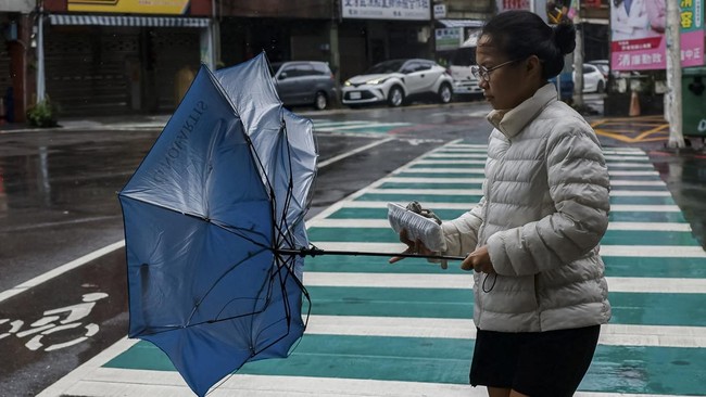 A pedestrian holds an umbrella in strong winds as Typhoon Champi approaches Taiwan, in Keelung, Taiwan, October 23, 2026. REUTERS/Ann Wang