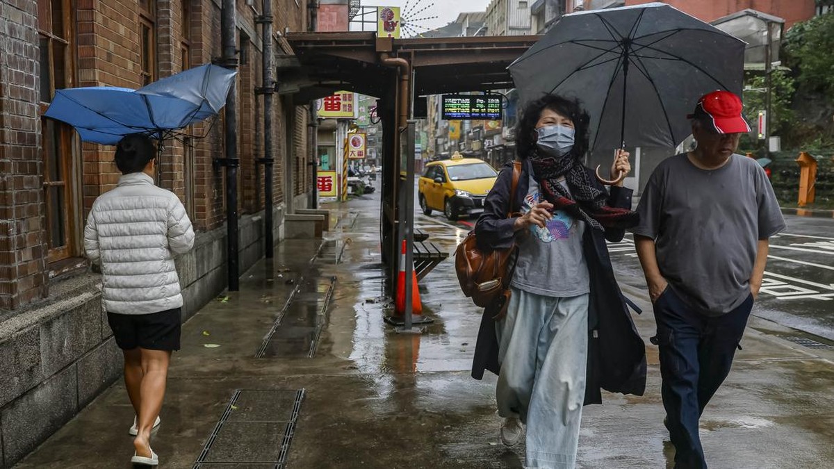 Pedestrians walk along a street as Typhoon Champi approaches Taiwan, in Keelung, Taiwan, October 23, 2026. REUTERS/Ann Wang     TPX IMAGES OF THE DAY