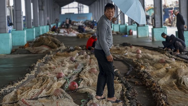 A fisherman walks among fishing nets at a fishing port as Typhoon Champi approaches Taiwan, in Keelung, Taiwan, October 23, 2026. REUTERS/Ann Wang