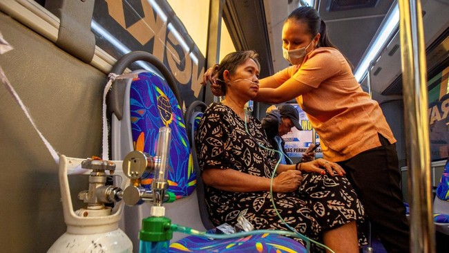A resident receives oxygen from a free mobile oxygen bus deployed by the city government amid haze from wildfires in Palangka Raya, Central Kalimantan province, Indonesia, October 23, 2026. REUTERS/Arief Rahman Septian Prathama
