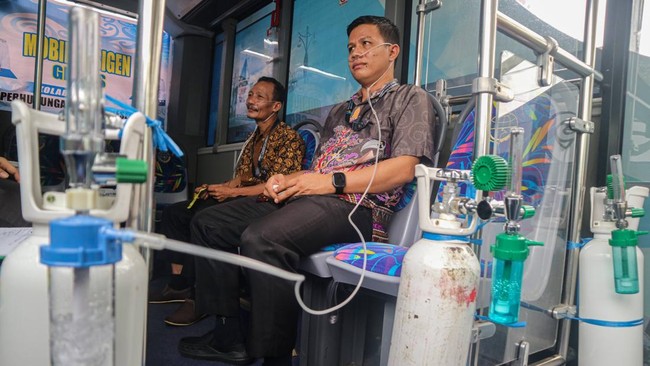 Warga memanfaatkan layanan mobil oksigen gratis di Palangka Raya, Kalimantan Tengah, Kamis (22/10/2026). Pemerintah Kota Palangka Raya menyediakan layanan mobil bus oksigen gratis keliling yang menjangkau wilayah padat penduduk sebagai upaya pertolon