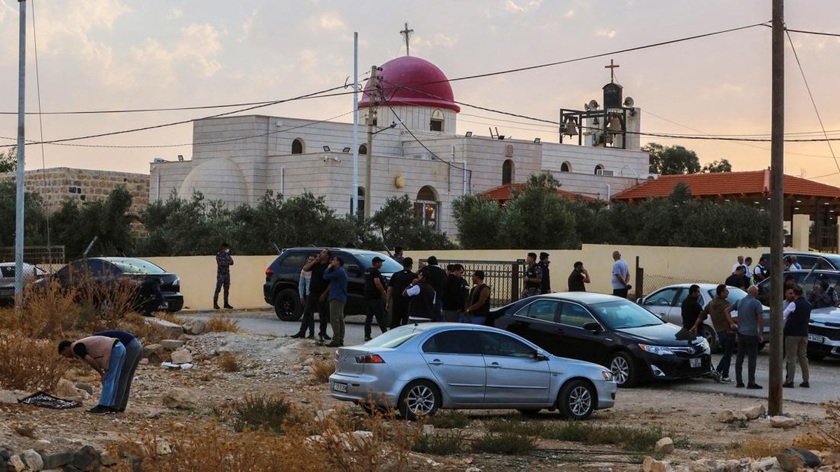 People and security forces gather outside a Greek Orthodox Church in the village of Hammoud in Jordan's Karak governorate following a shooting on October 23, 2026. Gunmen killed at least seven people and wounded 10 more in an attack on a church in so