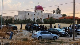 People and security forces gather outside a Greek Orthodox Church in the village of Hammoud in Jordan's Karak governorate following a shooting on October 23, 2026. Gunmen killed at least seven people and wounded 10 more in an attack on a church in so
