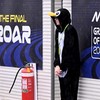 A spectator dressed in a penguin suit shelters from the heavy rain ahead at the Australian MotoGP Grand Prix on Phillip Island on October 25, 2026. (Photo by William WEST / AFP) / --IMAGE RESTRICTED TO EDITORIAL USE - STRICTLY NO COMMERCIAL USE--