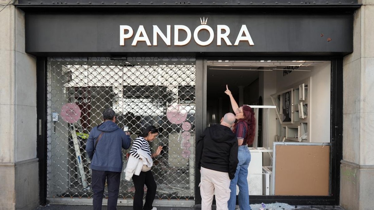 People look at a jeweller's shop looted the previous night during riots, in Barcelona on October 25, 2026. Police made 128 arrests overnight in Barcelona for acts of "vandalism", damage to public property" and "looting", the regional Catalan police s