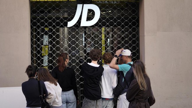 People take images of a shop looted the previous night during riots, in Barcelona on October 25, 2026. Police made 128 arrests overnight in Barcelona for acts of "vandalism", damage to public property" and "looting", the regional Catalan police said