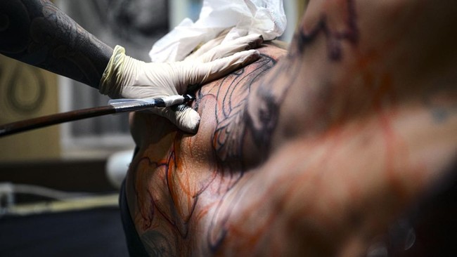 Japanese tattoo artist Horikashi, renowned for his expertise in the traditional hand-poking technique known as