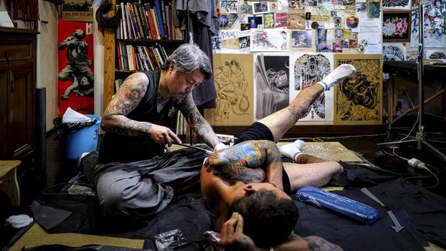 Japanese tattoo artist Horikashi, renowned for his expertise in the traditional hand-poking technique known as