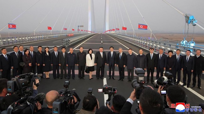 North Korean leader Kim Jong Un, Chinese People's Political Consultative Conference (CPPCC) Chairman Wang Huning, Chinese Foreign Minister Wang Yi, and North Korean Foreign Minister Choe Son Hui pose for a photograph with officials on the New Yalu Ri