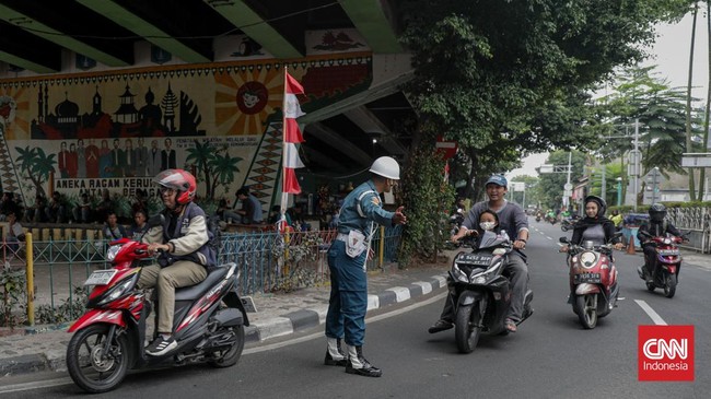 Sejumlah petugas kepolisian menilang pengendara sepeda motor dalam Operasi Patuh Jaya 2026 di Jalan Kemanggisan Raya, Slipi, Jakarta, Senin (26/10/2026). (CNN Indonesia/Febria Adha L)