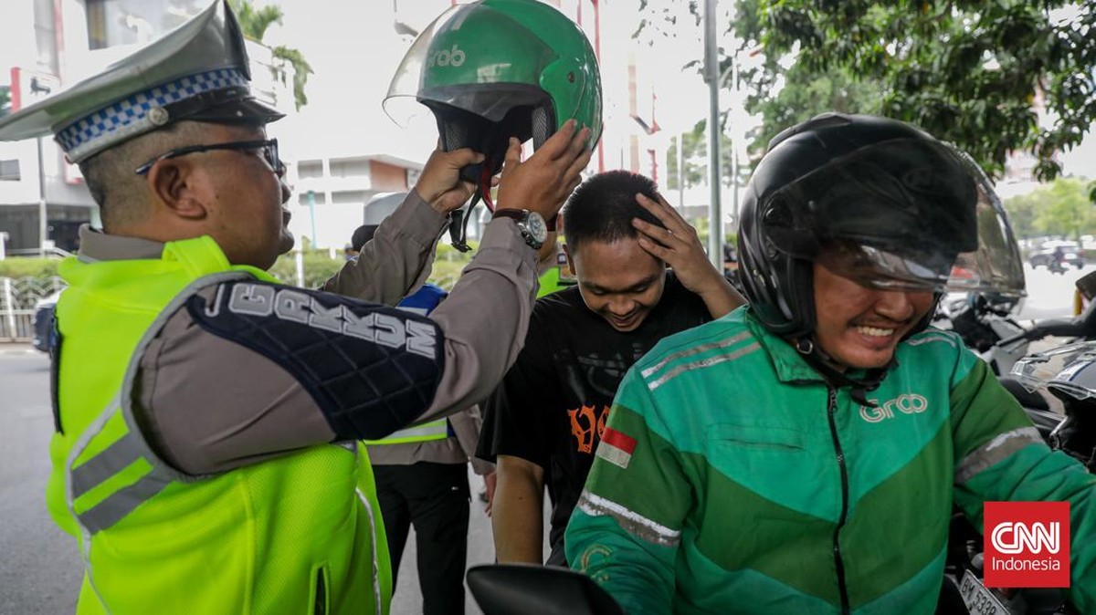 Sejumlah petugas kepolisian menilang pengendara sepeda motor dalam Operasi Patuh Jaya 2026 di Jalan Kemanggisan Raya, Slipi, Jakarta, Senin (26/10/2026). (CNN Indonesia/Febria Adha L)