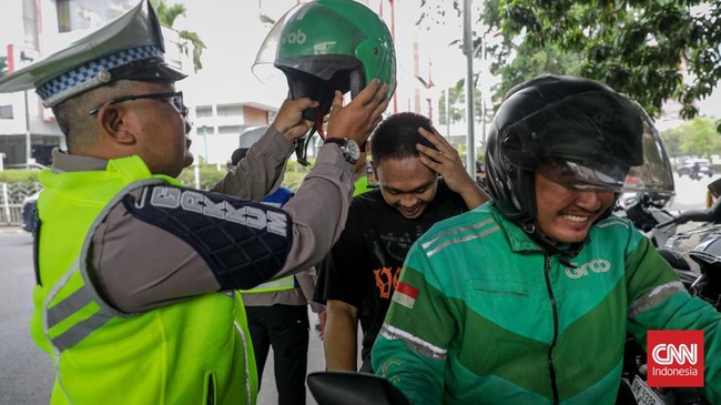 Sejumlah petugas kepolisian menilang pengendara sepeda motor dalam Operasi Patuh Jaya 2026 di Jalan Kemanggisan Raya, Slipi, Jakarta, Senin (26/10/2026). (CNN Indonesia/Febria Adha L)