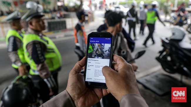 Sejumlah petugas kepolisian menilang pengendara sepeda motor dalam Operasi Patuh Jaya 2026 di Jalan Kemanggisan Raya, Slipi, Jakarta, Senin (26/10/2026). (CNN Indonesia/Febria Adha L)
