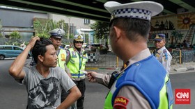 Sejumlah petugas kepolisian menilang pengendara sepeda motor dalam Operasi Patuh Jaya 2026 di Jalan Kemanggisan Raya, Slipi, Jakarta, Senin (26/10/2026). (CNN Indonesia/Febria Adha L)