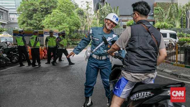 Sejumlah petugas kepolisian menilang pengendara sepeda motor dalam Operasi Patuh Jaya 2026 di Jalan Kemanggisan Raya, Slipi, Jakarta, Senin (26/10/2026). (CNN Indonesia/Febria Adha L)