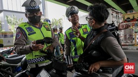 Sejumlah petugas kepolisian menilang pengendara sepeda motor dalam Operasi Patuh Jaya 2026 di Jalan Kemanggisan Raya, Slipi, Jakarta, Senin (26/10/2026). (CNN Indonesia/Febria Adha L)