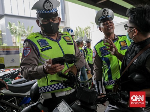 Sejumlah petugas kepolisian menilang pengendara sepeda motor dalam Operasi Patuh Jaya 2026 di Jalan Kemanggisan Raya, Slipi, Jakarta, Senin (26/10/2026). (CNN Indonesia/Febria Adha L)