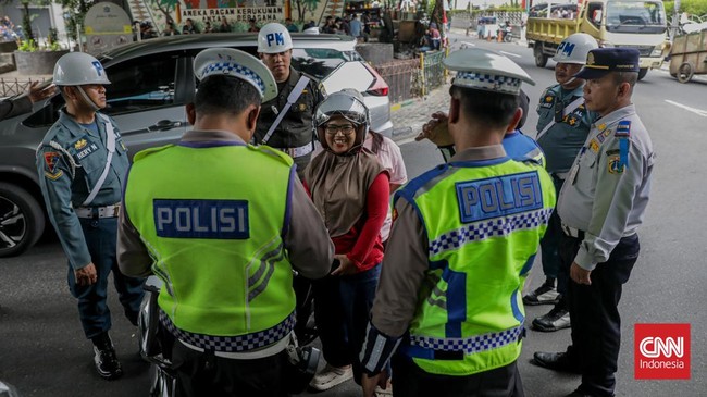 Sejumlah petugas kepolisian menilang pengendara sepeda motor dalam Operasi Patuh Jaya 2026 di Jalan Kemanggisan Raya, Slipi, Jakarta, Senin (26/10/2026). (CNN Indonesia/Febria Adha L)