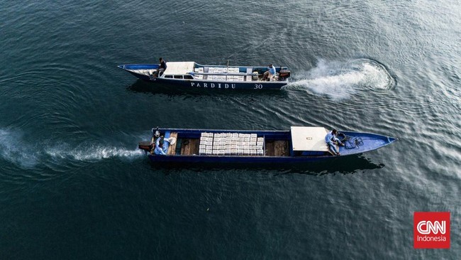 Petugas SPPG membawa paket Makan Bergizi Gratis (MBG) menggunakan armada perahu untuk didistribusikan ke tiga desa terluar di Maluku Utara.